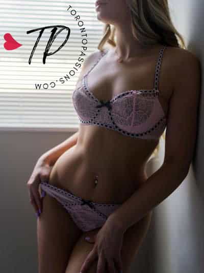 Woman in lace lingerie with soft lighting, Toronto escorts.