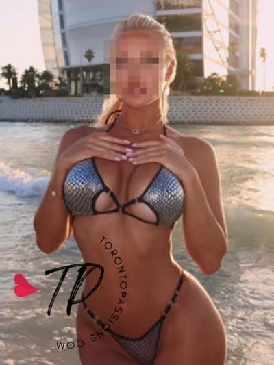 Blonde woman in a bikini at the poolside with cityscape background.
